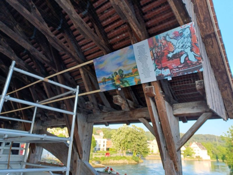 Foto der Installation von Bildern auf der Holzbrücke